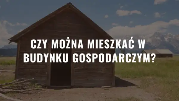 Drewniany budynek gospodarczy na tle gór i nieba.